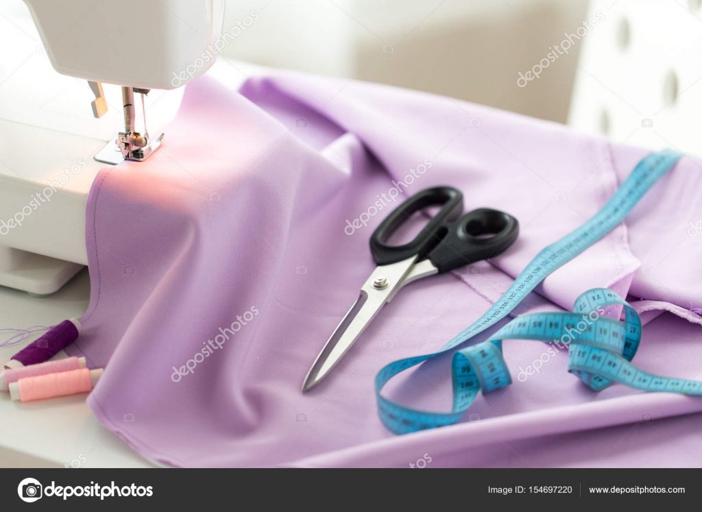 sewing machine, scissors, tape measure and fabric